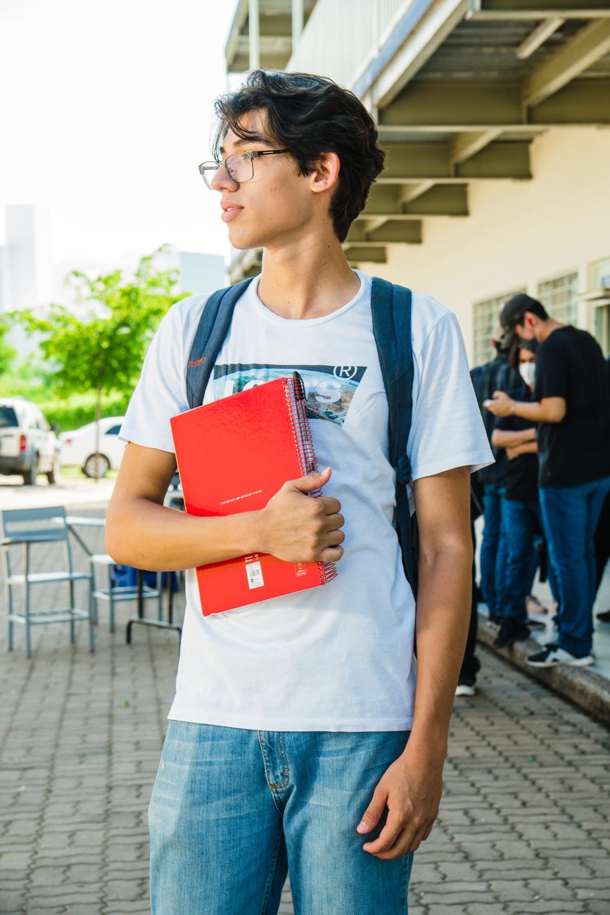 Estudante com caderno vermelho